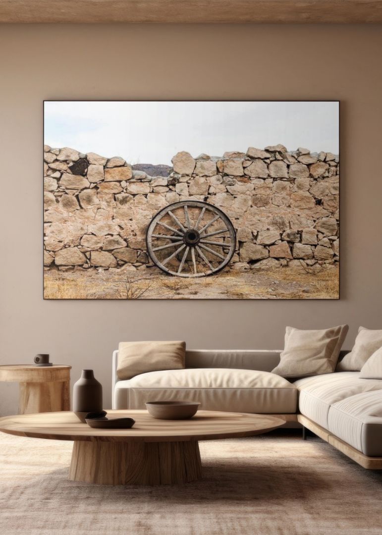 Wagon wheel against a stone fence