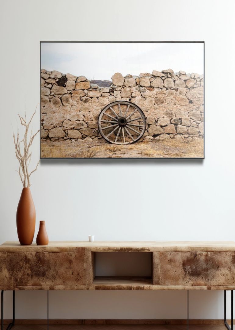 Wagon wheel against a stone fence