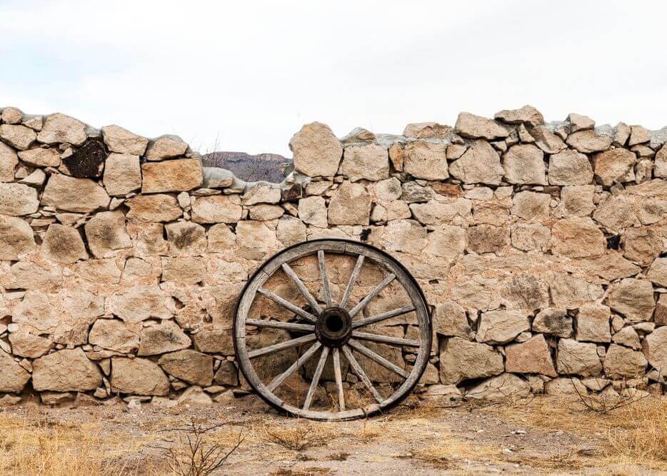 Wagon wheel against a stone fence